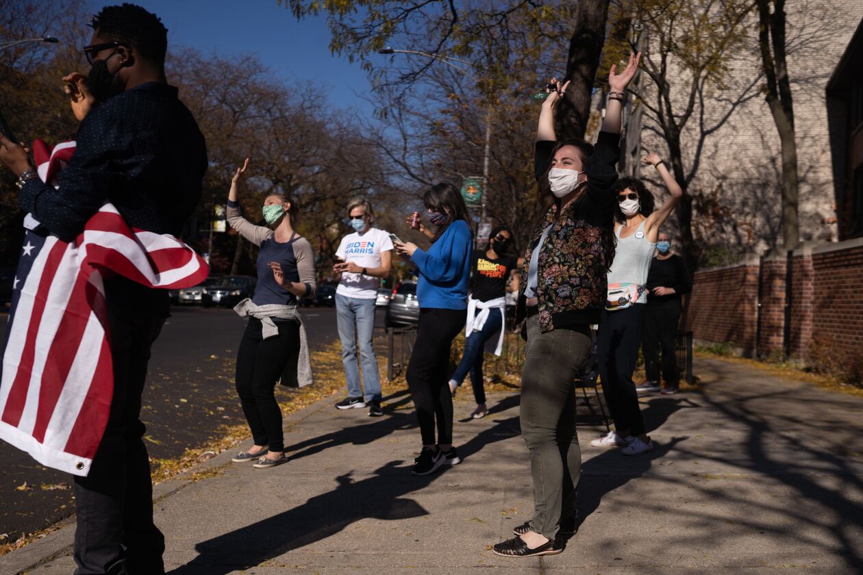 People cheer on North Sheridan Road in the Rogers Park neighborhood, where dozens gathered after President-elect Joe Biden’s victory was announced.